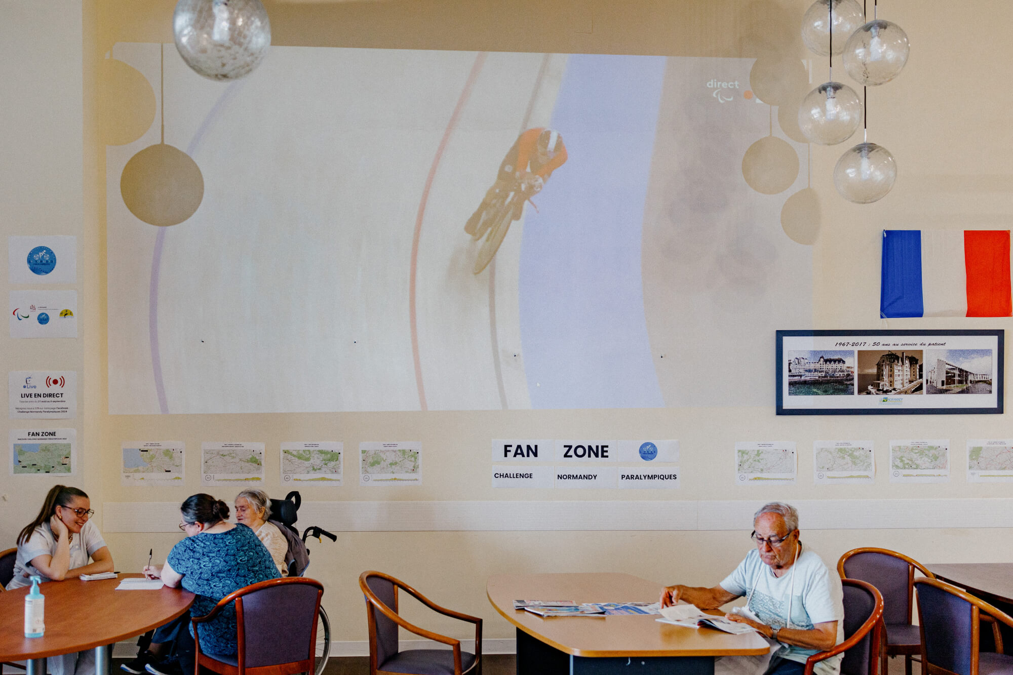 Les patients du centre de rééducation se retrouvent dans les fan zones de l'établissement pour boire un café, feuilleter les journaux ou regarder les Jeux paralympiques diffusés sur un rétroprojecteur. (PIERRE MOREL / FRANCEINFO)