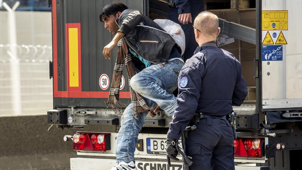 Un CRS fait descendre un migrant d'un camion, le 3 juin 2015 &agrave; Calais (Pas-de-Calais).