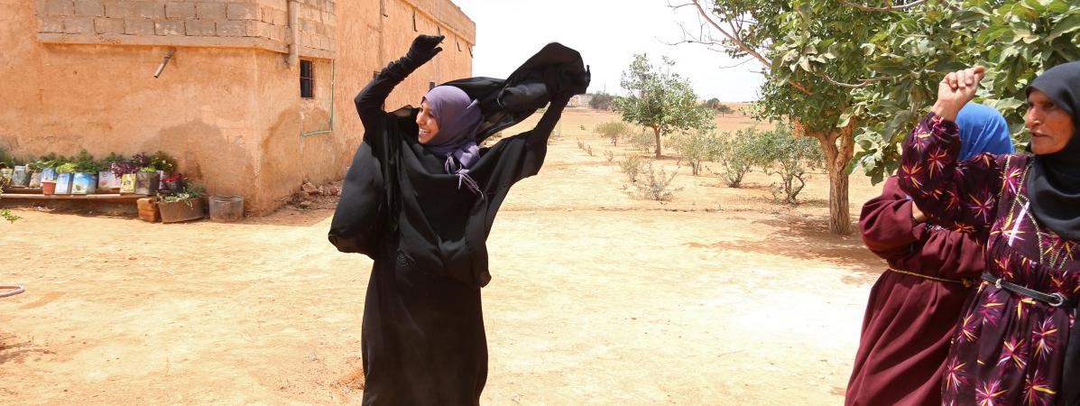 Une habitante enlève son voile intégral, après le départ de l'Etat islamique et la prise de contrôle de son village près de&nbsp;Minbej en Syrie par les&nbsp;Forces démocratiques syriennes, le 9 juin 2016.