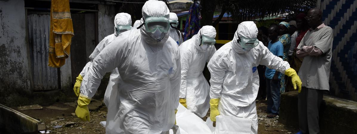 Des salariés de la Croix-Rouge portent le corps d\'une personne possible morte du virus Ebola, le 4 octobre 2014 à Monrovia (Liberia).&nbsp;