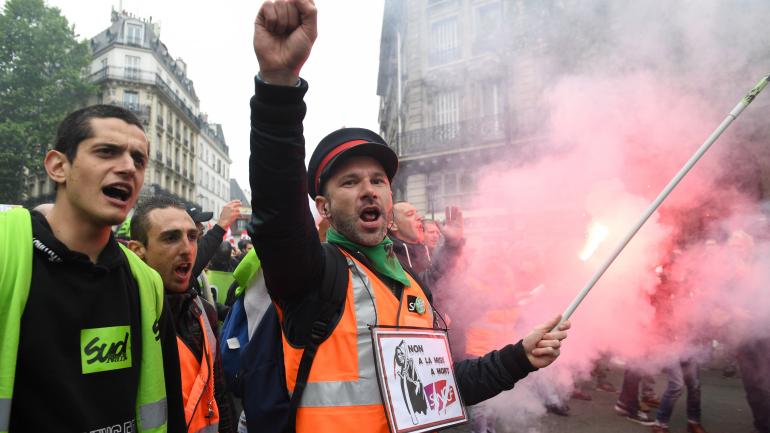 Deux salariés de la SNCF manifestent devant la gare de l\'Est, le 14 mai 2018 à Paris.