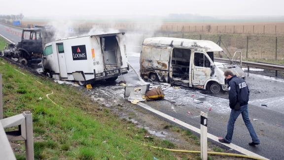 Un policier inspecte les lieux d\'un braquage de fourgon blindé, le 17 mars 2011, à Roclincourt (Pas-de-Calais).