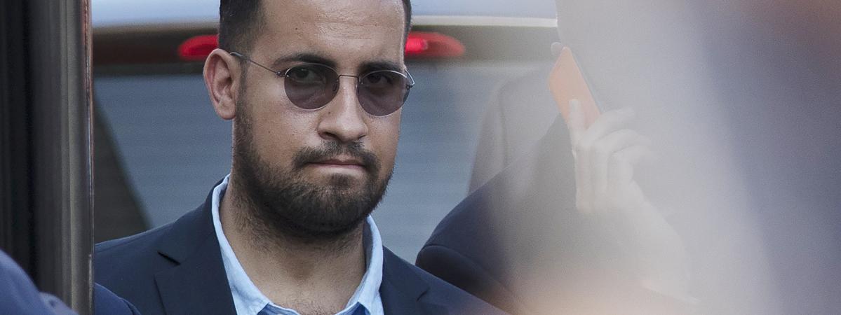 Alexandre Benalla à côté du bus de l\'équipe de France de football à l\'aéroport Roissy-Charles de Gaulle, le 16 juillet 2018.&nbsp;