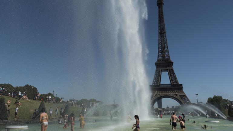 Des personnes se baignent au pied de la tour Eiffel, à Paris, le 6 août 2018.