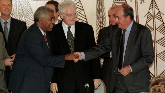 Le Premier ministre, Lionel Jospin (c), observe une poignée de mains entre l\'indépendantiste Roch Wamytan (g) et le non-indépendantiste Jacques Lafleur (d), le 5 juin 1998, après la signature d\'un accord à Nouméa (Nouvelle-Calédonie).