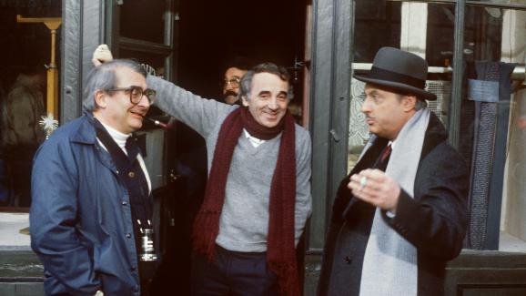 Charles Aznavour lors du tournage des \"Fantômes du chapelier\", le 20 janvier 1982 à Concarneau (Finistère), en compagnie du réalisateur Claude Cabrol (à gauche) et de Michel Serrault.