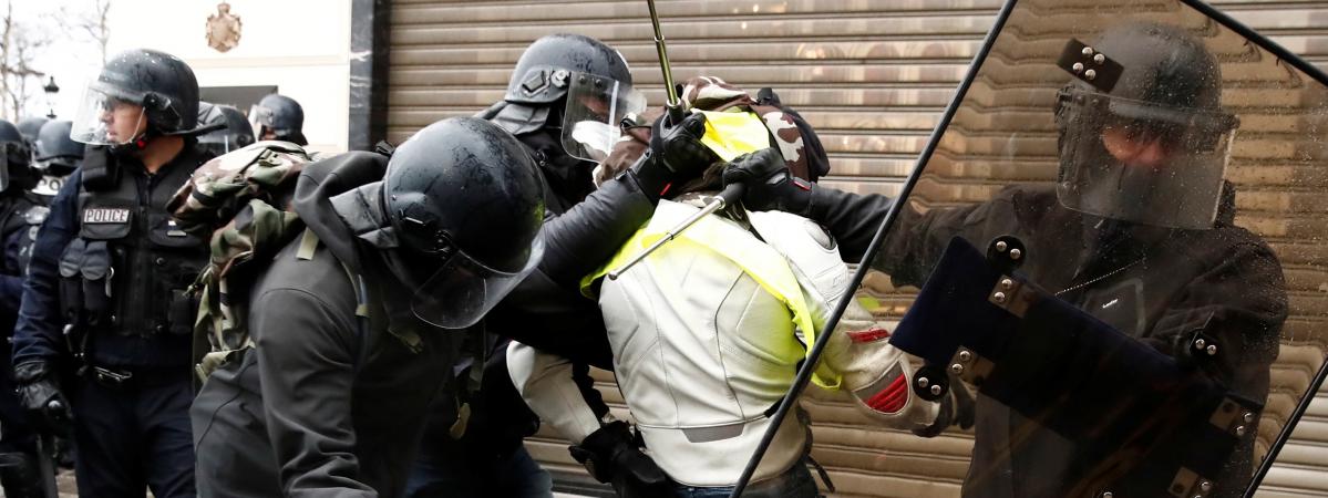 Des policiers appréhendent un manifestant en marge de la mobilisation des \"gilets jaunes\" à Paris, le 8 décembre 2018.