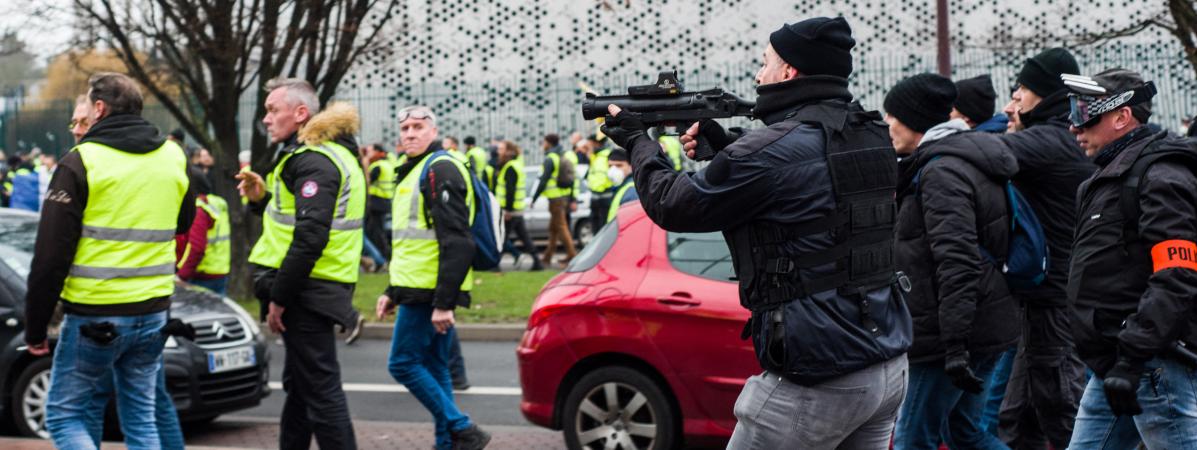 Un policier de la brigade anticriminalitÃ© point un lanceur de balle de dÃ©fense en direction de \"gilets jaunes\", le 29 dÃ©cembre 2018, Ã  Lille, lors d\'une manifestation.