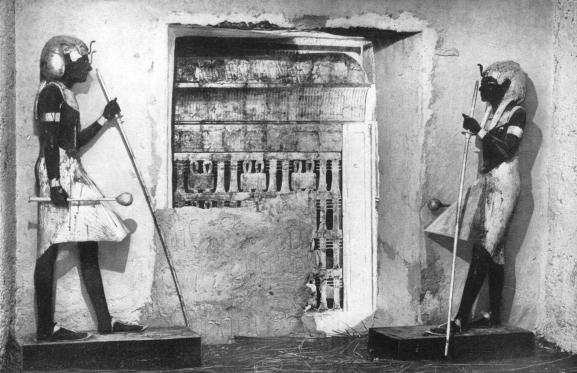 Deux statues royales encadrent&nbsp;la porte qui sépare l\'antichambre de la chambre funéraire de Toutankhamon, dans la Vallée des Rois (photo de 1934).