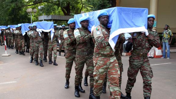 Des soldats nigériens de la Minusma portent les cercueils aux couleurs de l\'ONU de neufs soldats à Bamako, le 7 octobre 2014.