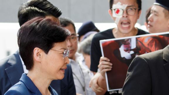 La cheffe du pouvoir exécutif de Hong Kong, Carrie Lam, passe devant des manifestants, devant son bureau, à Hong Kong, le 13 août 2019.