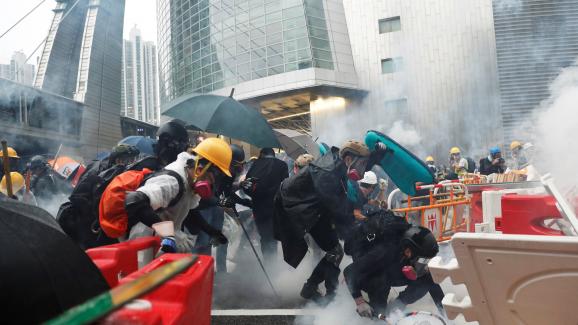 Des manifestants essuient des tirs de gaz lacrymogène de la police à Hong Kong, le 25 août 2019.