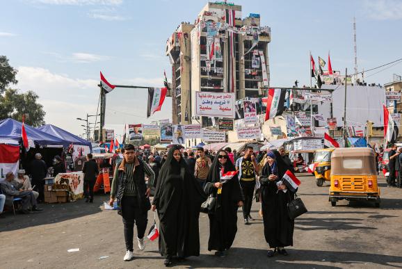 Des femmes tiennent des drapeaux irakiens, sur la place Tahrir, devant le bâtiment occupé par les manifestants, \"le restaurant turc\", le 23 novembre 2019, à Bagdad (Irak).&nbsp;