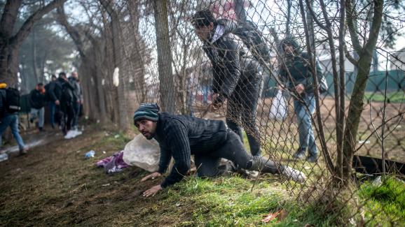 Un migrant traverse une barrière lors d\'affrontements avec la police grecque à Pazarkule, dans le district d\'Edirne, le 29 février 2020.