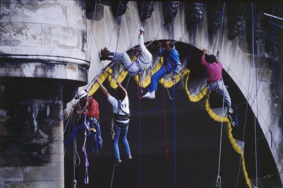 Des alpinistes attachent la toile hissée sous l\'une des arches du Pont Neuf&nbsp;