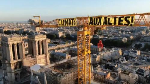 Greenpeace déploie une banderole sur la grue surplombant Notre-Dame de Paris pour dénoncer l'inaction climatique d'Emmanuel Macron