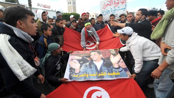 Des habitants de Kasserine portent une affiche de Mohamed Bouazizi, devant le palais du gouvernement à Tunis, le 28&nbsp;janvier 2011.