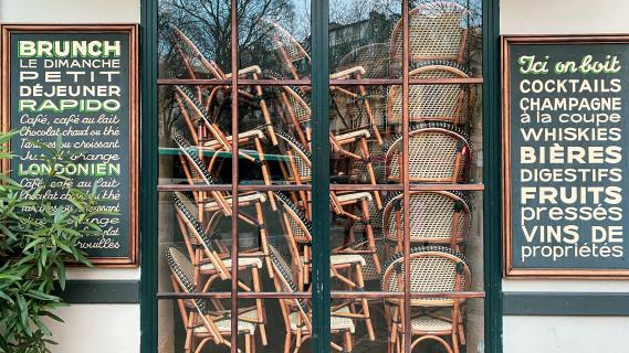 Des chaises et des tables sont empilées derrière la vitrine d'un café fermé à Paris, le 15 janvier 2021.