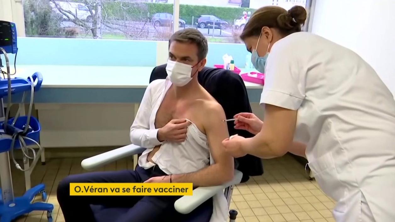 the Minister of Health, Olivier Véran, receives a first injection of vaccine