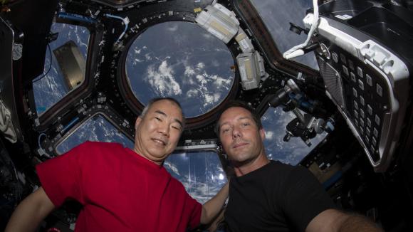 Cette photo de la NASA obtenue le 2 mai 2021, montre le japonais Soichi Wakata et Thomas Pesquet en train de poser pour un portrait le 28 avril 2021, à l\'intérieur de la capsule de l\'ISS, \"Fenêtre sur le monde\".&nbsp;