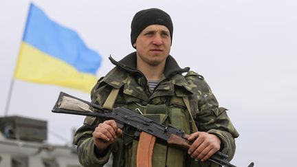 Un militaire ukrainien monte la garde &agrave; un point de contr&ocirc;le &agrave; l'ext&eacute;rieur du village de Tchongar, dans la r&eacute;gion de Kherson proche de la Crim&eacute;e, le 19 Mars 2014. (VALENTYN OGIRENKO / REUTERS)