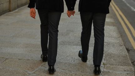 Deux hommes se tiennent la main dans les rues de Dublin (Irlande), le 27 novembre 2020. (ARTUR WIDAK / NURPHOTO / AFP)