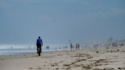 Des personnes sur une plage de Melbourne (Floride), avant le passage de l'ouragan Dorian. (RICARDO ARDUENGO / AFP)