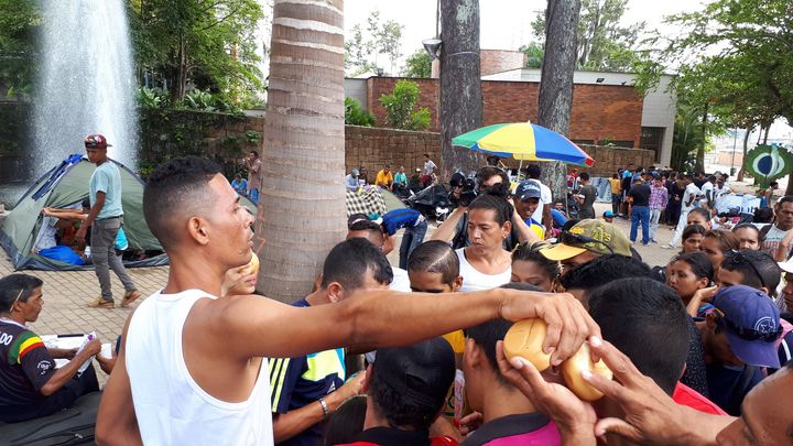 Une distribution de pain pour les migrants vénézuéliens dans le camp improvisé de&nbsp;Bucaramanga (Colombie). (BENJAMIN ILLY / RADIO FRANCE)