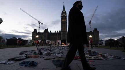 Le juge en chef de la Cour suprême Richard Wagner passe devant des chaussures laissées sur la colline du Parlement, à la veille de la première Journée nationale de vérité et de réconciliation, mercredi 29 septembre 2021 à Ottawa au Canada.&nbsp; (ADRIAN WYLD / MAXPPP)