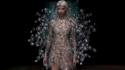 Pour sa collection intitulée "Aeriform", Iris van Herpen - adepte des matières innovantes et du travail entre mode, art et science - a présenté une collection autour des thèmes de l'air et de l'eau. La Néerlandaise a collaboré avec les artistes de "Between music", qui jouaient de la musique sous l'eau, dans des aquariums installés sur le podium. Autour d'eux évoluaient des silhouettes légères et poétiques, évoquant des créatures marines, des bulles d'air ou des nuages.
 (Patrick KOVARIK / AFP)