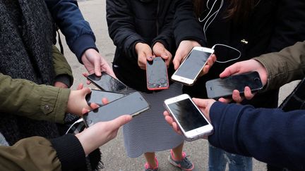 Des jeunes et leurs inséparables portables, à Thionville, le 8 février 2017. (JULIO PELAEZ / MAXPPP)