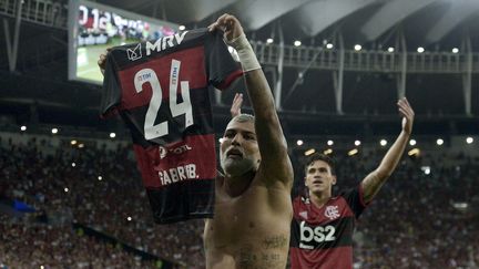 Gabriel Barbosa, dit "Gabigol", brandit son maillot de Flamengo floqué du numéro 24 lors d'une campagne contre l'homophobie au Brésil, le 22 février 2020. (DHAVID NORMANDO / AFP)