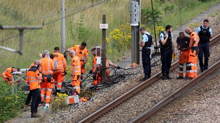 Des agents SNCF et des gendarmes inspectent des dégradations commises sur un site ferroviaire à Croisilles (Pas-de-Calais), le 26 juillet 2024. (DENIS CHARLET / AFP)