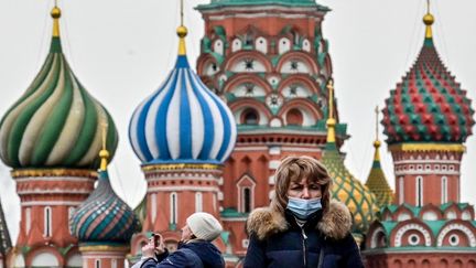 Une femme masquée devant la cathédrale Saint-Basile de Moscou (Russie), le 22 mars 2021. (YURI KADOBNOV / AFP)