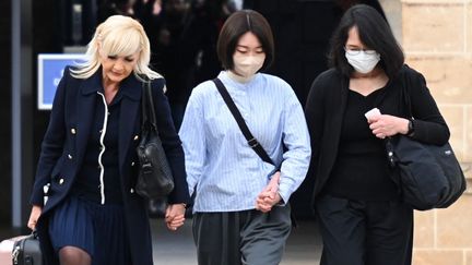 La sœur et la mère de Narumi Kurosaki arrivent à la cour d'assises de Besançon (Doubs) en compagnie de leur avocate, Sylvie Galley (à gauche), le 29 mars 2022. (SEBASTIEN BOZON / AFP)