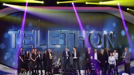 Sophie Davant entour&eacute;e de nombreux invit&eacute;s sur le plateau du T&eacute;l&eacute;thon, &agrave; Saint-Denis (Seine-Saint-Denis), le 7 d&eacute;cembre 2012. (BERTRAND GUAY / AFP)