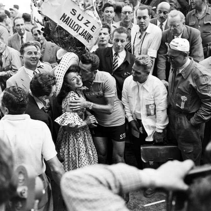 Le maillot jaune Louison Bobet embrasse l'accordéoniste Yvette Horner (avec le sombrero) à l'arrivée du Tour de France 1954, à Paris. (DANIEL FALLOT / INA)