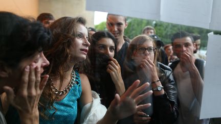 Des &eacute;l&egrave;ves d&eacute;couvrent leurs r&eacute;sultats au baccalaur&eacute;at au lyc&eacute;e Malherbe de Caen (Calvados), le 7 juillet 2015. (CHARLY TRIBALLEAU / AFP)