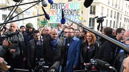 Des représentants syndicaux manifestent contre la réforme des retraites devant l'Assemblée nationale, le 16 mars 2023. (ALAIN JOCARD / AFP)