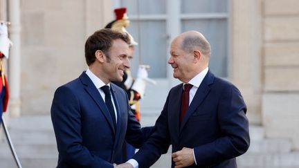 Le président français Emmanuel Macron accueillant le chancelier allemand Olaf Scholz à son arrivée pour un déjeuner au palais présidentiel de l'Elysée, à Paris, le 26 octobre 2022. (LUDOVIC MARIN / AFP)