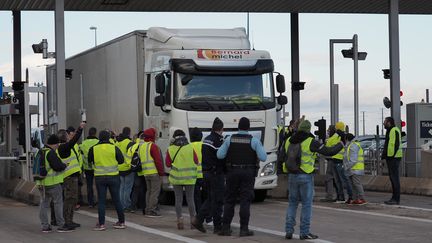 Des "gilets jaunes" laissent un conducteur passer gratuitement à un péage sur l'autoroute A10, à Blois (Loir-et-Cher), le 24 novembre 2018. (GUILLAUME SOUVANT / AFP)