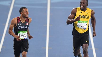 Andre De Grasse et Usain Bolt à l'arrivée de la deuxième demi-finale  (PEDRO UGARTE / AFP)