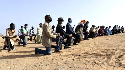 Des manifestants, genou à terre à Dakar (Sénégal), rassemblés pour soutenir le mouvement Black Lives Matter après la mort de George Floyd aux Etats-Unis, tué lors de son interpellation par des officiers de la police de Minneapolis.&nbsp;&nbsp; (SEYLLOU / AFP)