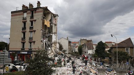 Pompiers et sauveteurs fouillent les gravas &agrave; la recherche d'&eacute;ventuelles victimes, le 31 ao&ucirc;t 2014, apr&egrave;s l'effondrement d'un immeuble &agrave; Rosny-sous-Bois (Seine-Saint-Denis). (MAXPPP)