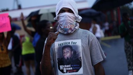 Un manifestant affiche sur son tee-shirt la photo de Michael Brown, le 15 ao&ucirc;t 2014. (JOSHUA LOTT / AFP)