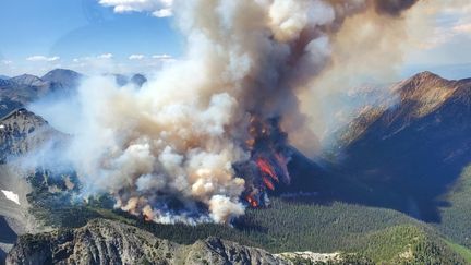 Un incendie près d'un lac en Colombie-Britannique, le 10 juillet 2023, au Canada. Les mégafeux qui ravagent le pays cet été, favorisés par un temps chaud, sec et venteux, brûlent au total 13,7 millions d'hectares, soit l'équivalent du territoire de la Grèce. (BC WILDFIRE SERVICE / ANADOLU AGENCY / AFP)