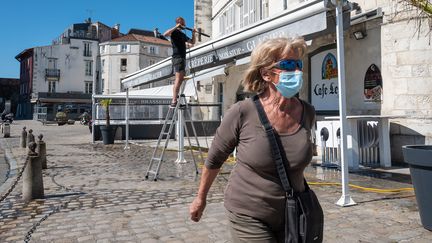 Une femme porte un masque dans le quartier&nbsp;du Vieux-Port de La Rochelle (Charente-Maritime), le 30 mai 2020. (XAVIER LEOTY / MAXPPP)