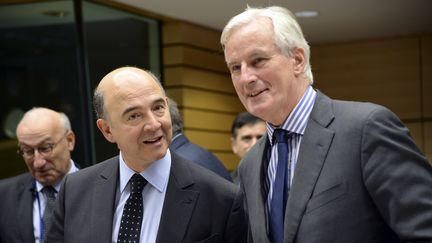 A Bruxelles, le 18 d&eacute;cembre 2013, Pierre Moscovici (ministre de l'Economie) et Michel Barnier (commissaire europ&eacute;en charg&eacute; des Services). (THIERRY CHARLIER / AFP)