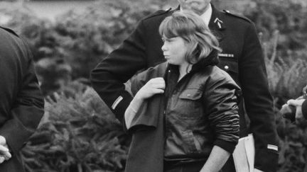 Murielle Bolle, témoin-clé dans l'affaire Grégory, entourée de gendarmes le 7 novembre 1984. (JEAN-CLAUDE DELMAS / AFP)