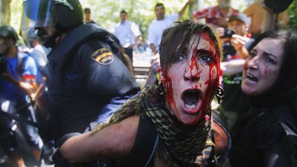 Une manifestante bless&eacute;e est d&eacute;tenue par la police apr&egrave;s les violents affrontements entre les mineurs de la "Marche noire" et les forces de l'ordre &agrave; Madrid (Espagne), le 11 juillet 2012. (ANDRES KUDACKI / AP / SIPA)